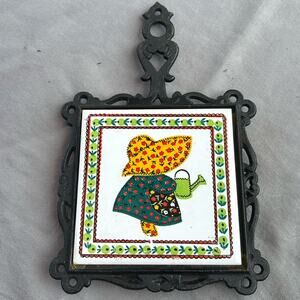 Vintage Cast Iron Trivet with Tile Inset Calico Girl wearing a bonnet